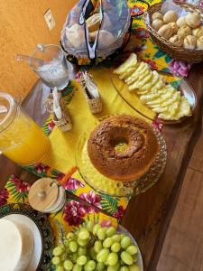 een tafel met borden met levensmiddelen en druiven bij Pousada Cipó Cana in Santana do Riacho