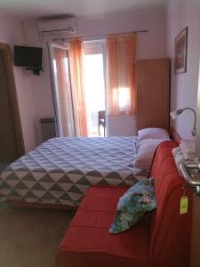 ein Schlafzimmer mit einem Bett und einem Sofa darin in der Unterkunft Apartments with a parking space Vrsi - Mulo, Zadar - 17753 in Vrsi