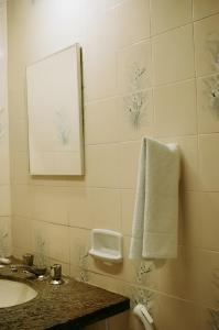 een badkamer met een wastafel en een witte handdoek bij Olympia Hotel in Lorena