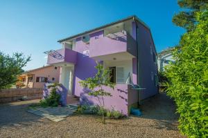 a pink and purple house with the door open at Apartments by the sea Starigrad, Paklenica - 17772 in Starigrad