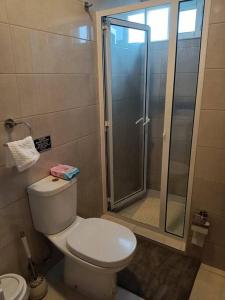 a bathroom with a toilet and a glass shower at New, Modern, and Cozy 3 Bedroom Apartment. in Santa Maria