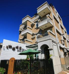 a building with a green umbrella in front of it at Sunny Breeze Garden Homestay in Jiali