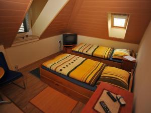 two beds in a small room with a tv at Apartments by the sea Sutivan, Brac - 17796 in Sutivan