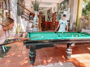 a woman and a young boy playing pool at Phong Nha Tuan Garden House in Phong Nha