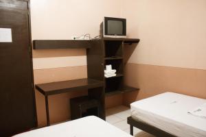 a room with a tv and a desk and a bed at GV Hotel - Catbalogan in Catbalogan