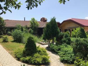 un jardin avec des arbres et des buissons en face d'une maison dans l'établissement Family friendly apartments with a swimming pool Ostarski Stanovi, Plitvice - 17806, à Rakovica