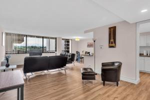 Arlington 2BR 2Ba Apartment in Crystal City apts في أرلينغتون: غرفة معيشة مع كراسي سوداء وطاولة