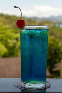 a blue drink with a cherry on a table at Asia Grand View Hotel in Coron
