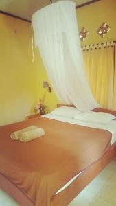 - une chambre avec un lit et un rideau blanc dans l'établissement Family bungalow, à Gili Meno