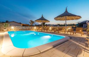 a swimming pool with chairs and umbrellas at Family friendly apartments with a swimming pool Drage, Biograd - 17819 in Pakoštane