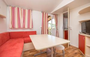 uma sala de estar com um sofá vermelho e uma mesa em Family friendly apartments with a swimming pool Drage, Biograd - 17819 em Pakoštane