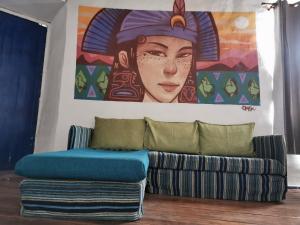 a couch in a room with a painting on the wall at Vientos - La Yareta in San Pedro de Atacama
