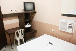 a small room with a bed and a desk with a television at GV Hotel - Catbalogan in Catbalogan