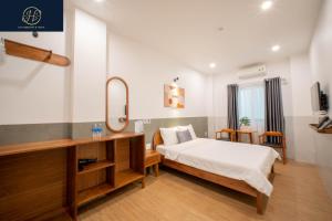 a bedroom with a bed and a mirror at OH FAMILY QUY NHON HOMESTAY in Quy Nhon