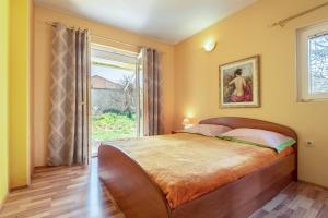 a bedroom with a large bed and a window at Apartments by the sea Kraj, Pasman - 17783 in Tkon