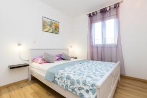 a bedroom with a bed and a window at Apartments and rooms with parking space Grebastica, Sibenik - 17831 in Šibenik