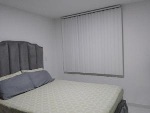 een slaapkamer met een bed en een raam met jaloezieën bij Apartamento en el centro de la ciudad bonita a muy buen precio in Bucaramanga