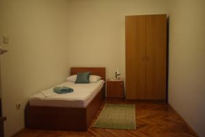 niewielka sypialnia z łóżkiem i drewnianą szafką w obiekcie Apartments by the sea Starigrad, Paklenica - 17865 w mieście Starigrad-Paklenica