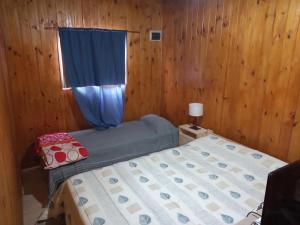 ランチョスにあるComplejo cabañas el parajeの小さなベッドルーム(ベッド1台、窓付)