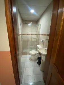 Un baño con ducha, inodoro y lavabo. en Hostal el Paraíso, en Cuenca