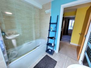 een badkamer met een bad en een wastafel bij Luxury 2-Bedroom Service Apartment with Balcony in Manchester