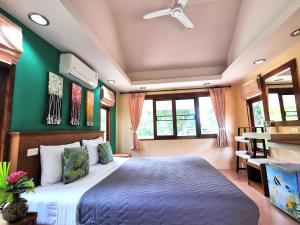 - une chambre avec un lit et un mur vert dans l'établissement Phalarn Inn Resort, à Mae Nam Beach