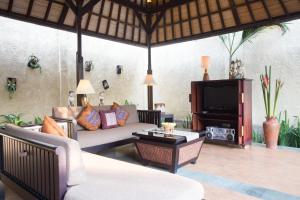 a living room with a couch and a tv at The Sanyas Suite Bali in Seminyak