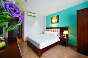 Un dormitorio con una cama y una pared azul. en Cherry Central Hotel- Near Opera House, en Ho Chi Minh
