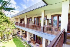an exterior view of a building with balconies at Sakura Guest House in Canggu