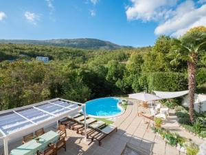 an image of a swimming pool and patio with chairs and umbrellas at Family friendly house with a swimming pool Zagore, Opatija - 17924 in Mošćenička Draga