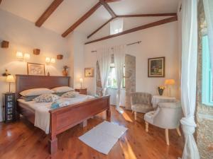 a bedroom with a large bed and a chair at Family friendly house with a swimming pool Zagore, Opatija - 17924 in Mošćenička Draga