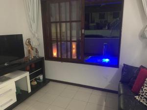 una sala de estar con una pecera en una ventana en Casa com 3 Suites à 200m da Praia - Barra de São Miguel en Barra de São Miguel