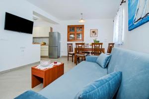een woonkamer met een blauwe bank en een tafel bij Apartments by the sea Rovinj - 17935 in Rovinj