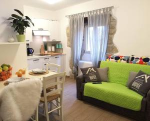 a living room with a green couch and a kitchen at Apartments and rooms with parking space Hum, Central Istria - Sredisnja Istra - 17939 in Roč