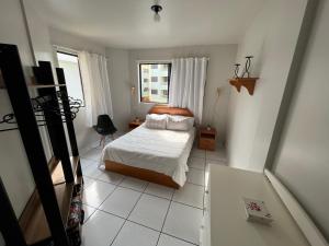 ein kleines Schlafzimmer mit einem Bett und einem Fenster in der Unterkunft Precioso apartamento frente al mar in Florianópolis