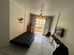 Zimmer mit schwarzem Sofa und Fenster in der Unterkunft Precioso apartamento frente al mar in Florianópolis