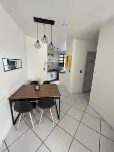 eine Küche und ein Esszimmer mit einem Holztisch und Stühlen in der Unterkunft Precioso apartamento frente al mar in Florianópolis