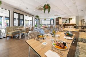 ein Restaurant mit Tischen und Stühlen mit Essen darauf in der Unterkunft Coral Cay Resort in Mackay