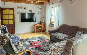 uma sala de estar com um sofá e uma televisão de ecrã plano em Beautiful Home In Slawno With 3 Bedrooms And Wifi em Sławno