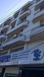 un bâtiment avec un panneau sur son côté dans l'établissement Cerca de todo, à Ciudad del Este