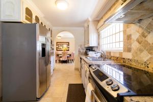 a kitchen with a stainless steel refrigerator and a table at Bianca Bay 3 Bedroom West Coast Beach Front Villa in Saint James
