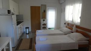 une petite chambre avec deux lits et une cuisine dans l'établissement Apartments by the sea Novalja, Pag - 17859, à Novalja