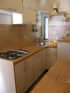 Il comprend une cuisine équipée d'un évier et d'une cuisinière. dans l'établissement Apartments by the sea Primosten - 17975, à Primošten