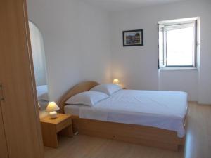 - une petite chambre avec un lit et une fenêtre dans l'établissement Apartments by the sea Primosten - 17975, à Primošten