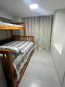 a small bedroom with a bed and a window at Maui - Tamandare - Carneiros in Tamandaré