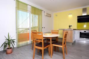 una cucina e una sala da pranzo con tavolo e sedie di Family friendly apartments with a swimming pool Klis, Split - 17987 a Klis