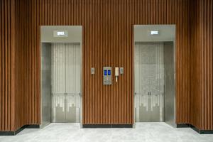 a row of three elevators in a building at The ONRA Hotel in Phnom Penh