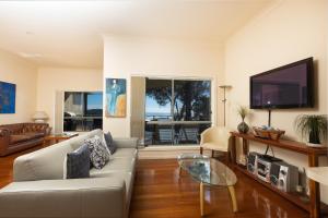 a living room with a couch and a flat screen tv at Seachange in Forster