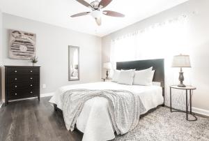 biała sypialnia z łóżkiem i wentylatorem sufitowym w obiekcie Stylish OneBedroom in Popular Virginia Highland w Atlancie