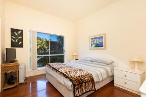 a white bedroom with a bed and a window at Seachange in Forster
